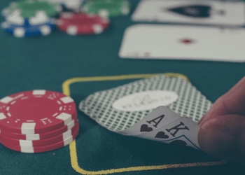 Pelaaja paljastaa korttinsa pokerimerkkien ympäröimänä