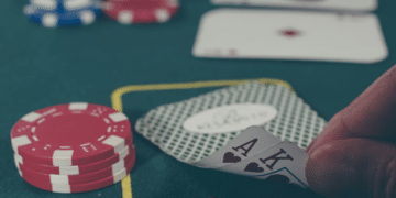 Pelaaja paljastaa korttinsa pokerimerkkien ympäröimänä